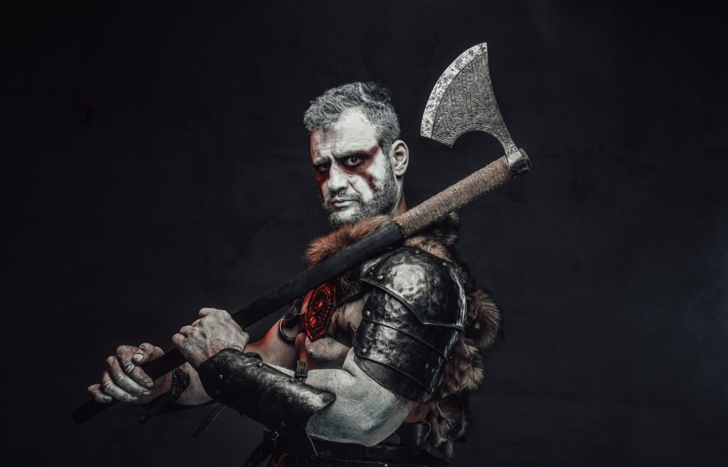 Serious fantasy barbarian with axe in dark background