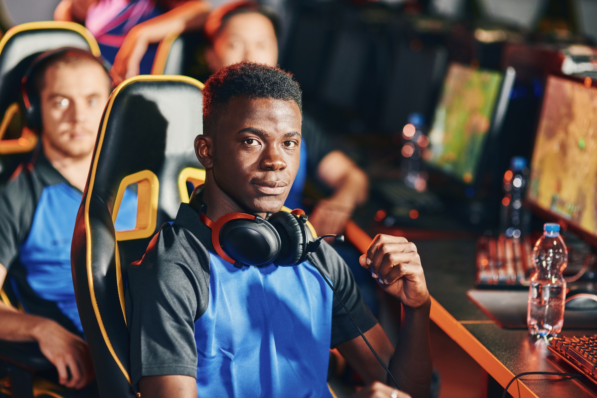Professional cybersport gamer looking at camera with serious facial expression, participating with